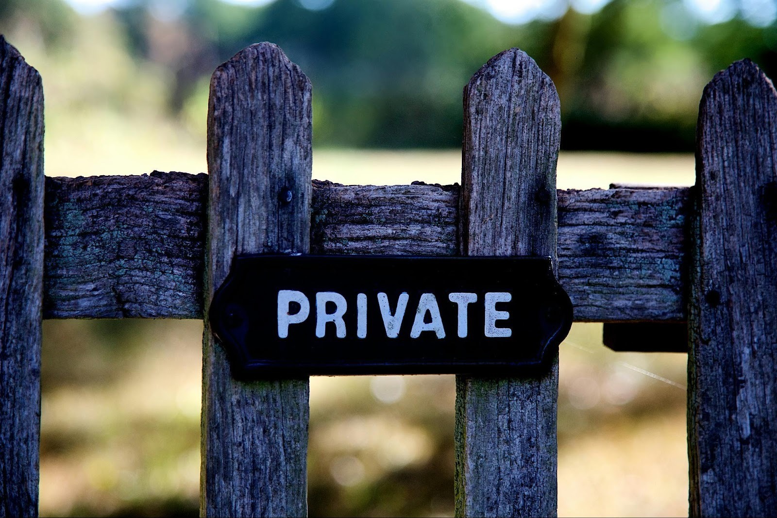 "Private" sign on a wooden fence, representing data privacy compliance and the strategy of using gated content for lead generation.